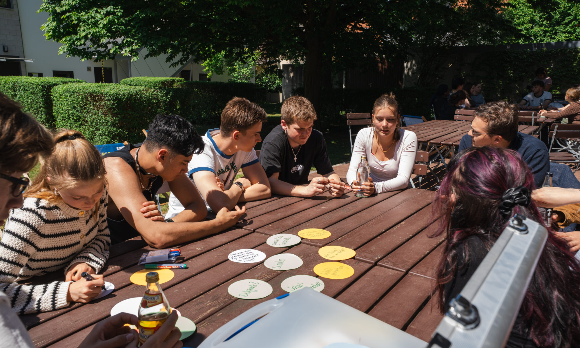 Jugendliche versammelt um einen Tisch während eines Workshops